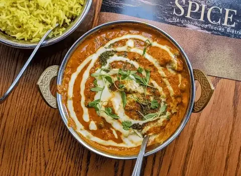 Butter chicken in copper bowl at SPICE ROOM