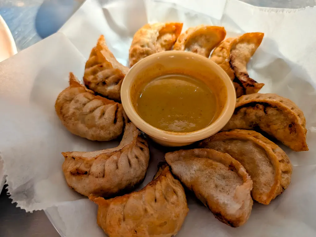 Fried Momos – Golden crispy Himalayan dumplings arranged around a tangy dipping sauce | SPICE ROOM Denver