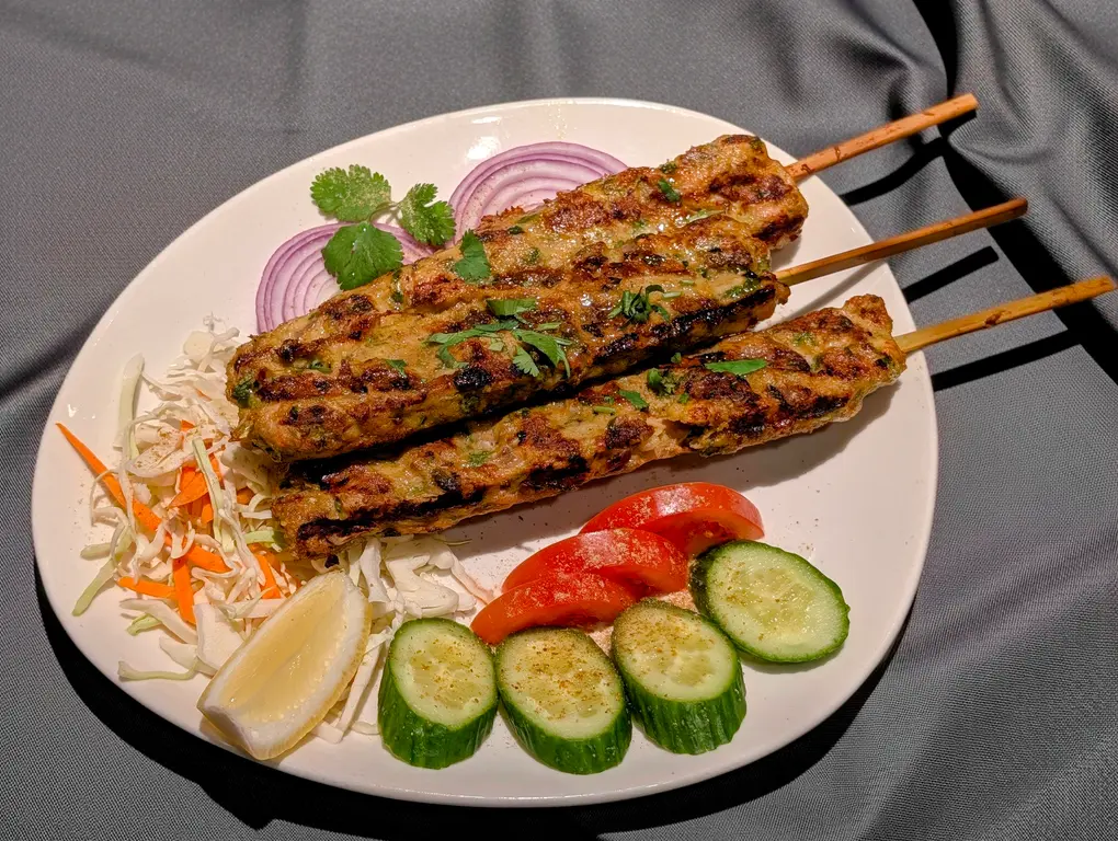 Seekh Kebab Platter – Charcoal-grilled minced lamb skewers served with fresh salad, cucumber, and lemon | SPICE ROOM Denver