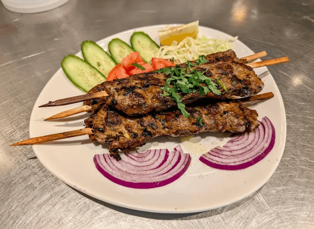 Seekh Kebab – Spiced minced lamb moulded on skewers and grilled over charcoal — served with fresh salad | SPICE ROOM Denver