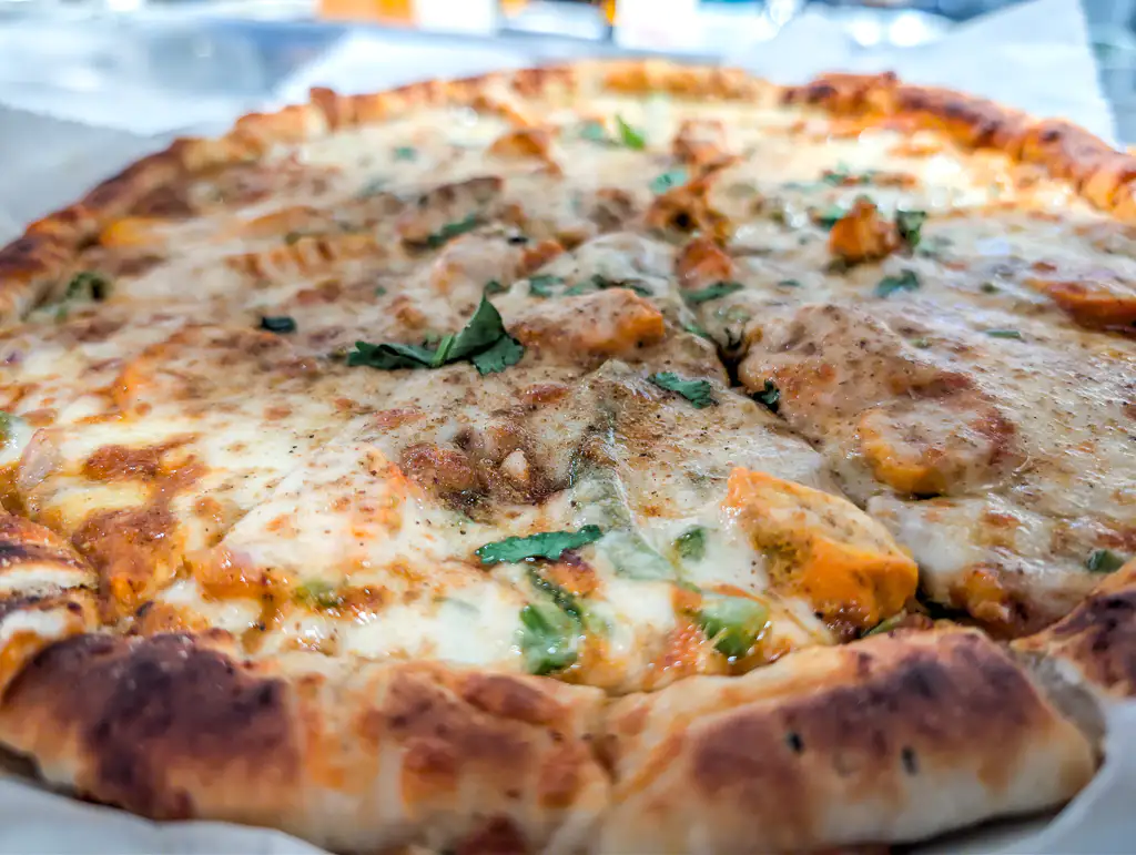 Tikka Pizza – Indo-Italian fusion — naan-crust pizza topped with tikka masala and mozzarella | SPICE ROOM Denver